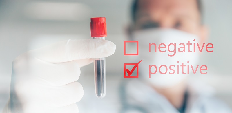 doctor holding positive COVID-19 test, possible answers for long COVID in blood test