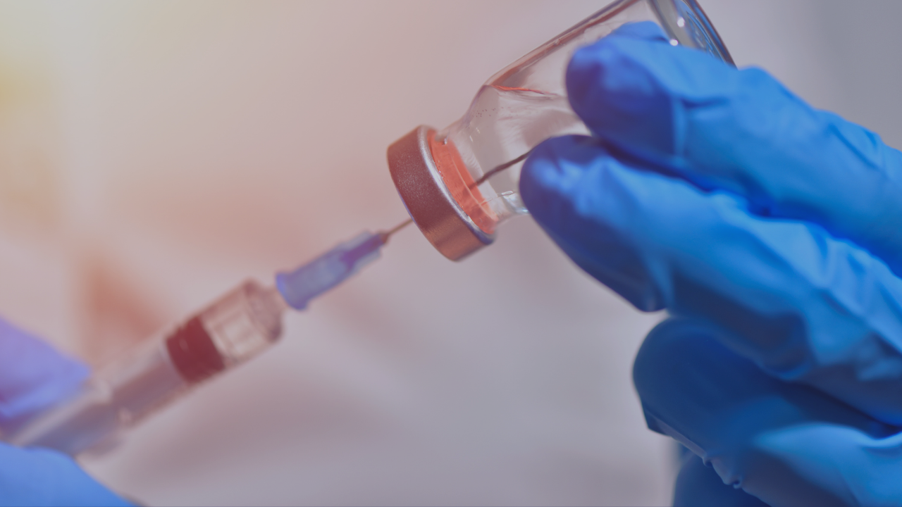 covid vaccine for the unvaccinated in gloved hands with a syringe in the bottle