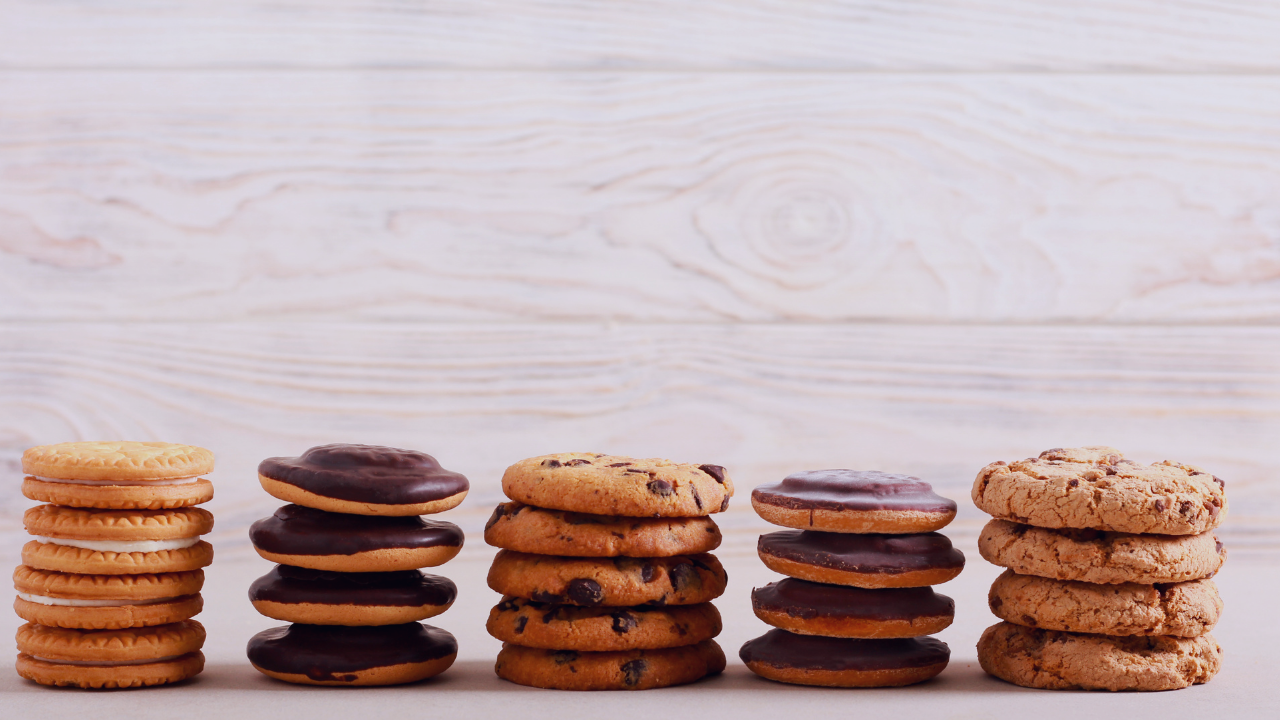 girl scout cookie flavors spread out and stacked in front of a white wooden background