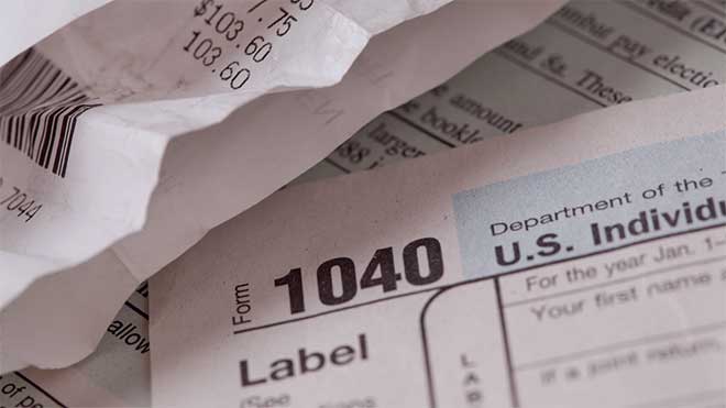 IRS tax return forms with receipts for itemized or standard deductions this tax season in 2022