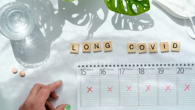 long COVID spelled on wooden tiles near calendar 