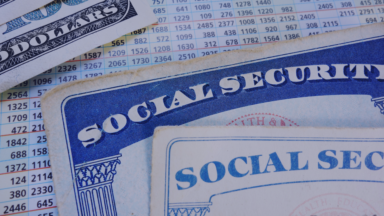 social security cards with cash and a chart showing amounts that people can qualify for with social security benefits
