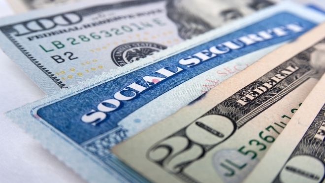 Social security card with cash representing benefits after a COLA increase