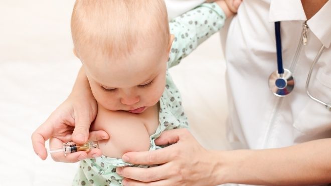 health care professional administers COVID-19 vaccine to child under 5 years old