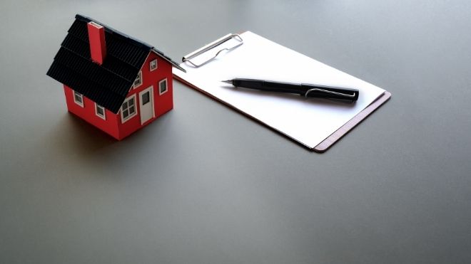 home next to paperwork on a clipboard representing mortgage lock rates