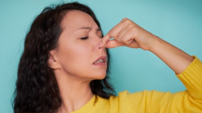 Woman holding nose, COVID-19 took sense of smell