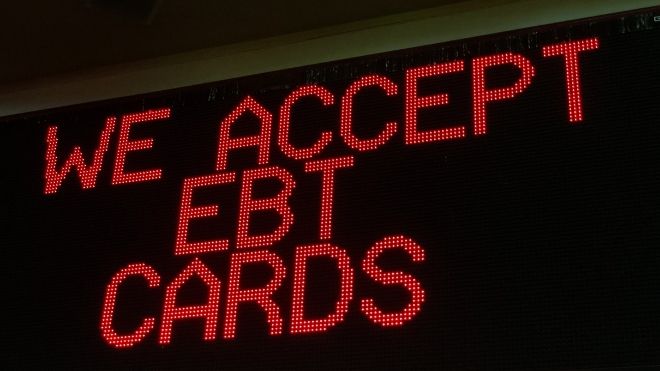 a sign in a grocery store where ebt cards and food stamps can be used to purchase SNAP eligible items