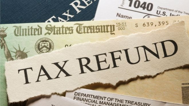 tax refund text across a check from the IRS and tax return paperwork