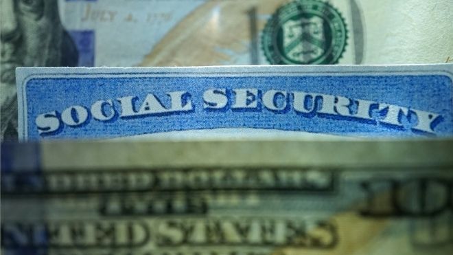 Social Security card with cash representing benefits that may increase due to COLA