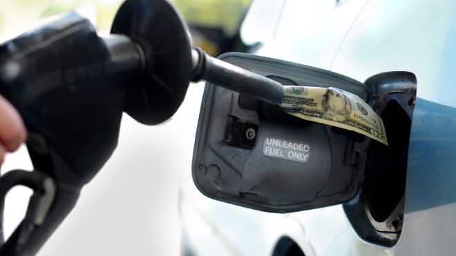 gas being put into a car, and new car sales with gas will soon end in California for electric vehicles.