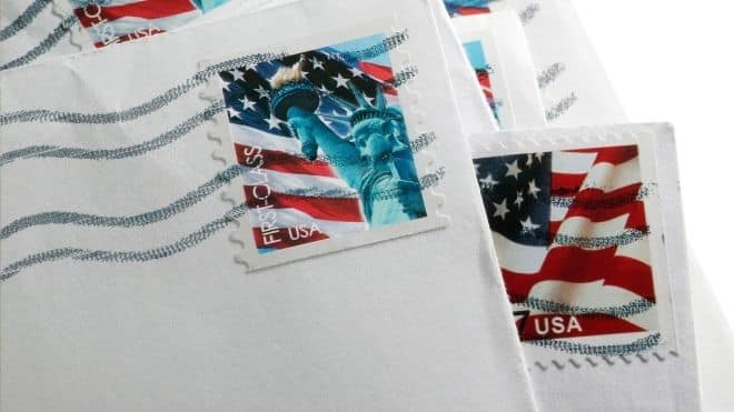 Stamps on an envelope from the USPS where they have increased prices.