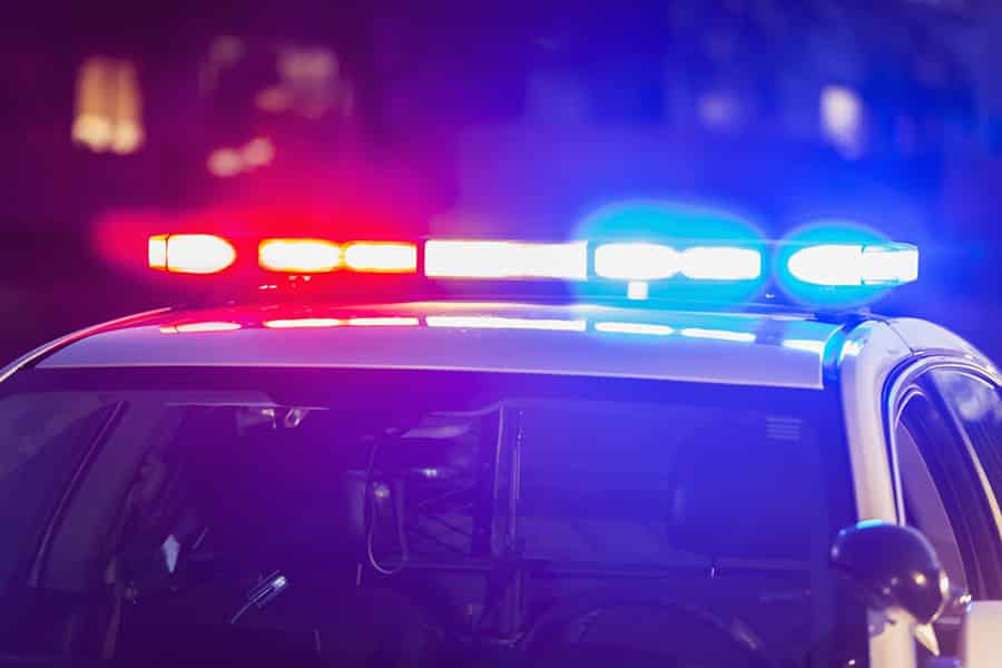 Generic police cruiser with red and blue lights at night