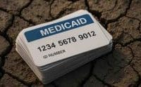 Pile of medicaid cards on cracked earth.