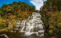 A waterfall flows through colorful autumn foliage